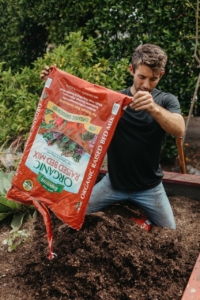 Farmer Nick dumping Espoma Raised bed Mix into a raised garden bed
