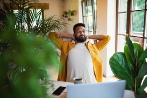 man working in an office filled with plants