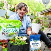 Maria from Growing Joy with Maria with plants and organic potting soil and organic fertilizer from Espoma Organic Potting Mix and Bio-tone on her balcony