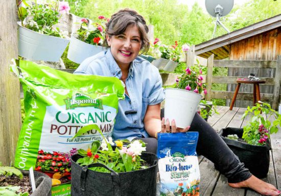 Maria from Growing Joy with Maria with plants and organic potting soil and organic fertilizer from Espoma Organic Potting Mix and Bio-tone on her balcony